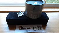 Swarovski crystal orchid flower figurine on black velvet display surface with original cylindrical box behind it