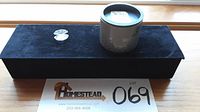 Photo showing the crystal shell figurine displayed on a black velvet pad next to its original cylindrical box with Swarovski branding.