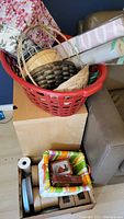 Red basket filled with various baskets, fabric liners, and items including candle holders and hooks.