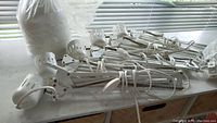 Multiple white posable clamp lights with adjustable arms and clips arranged on a flat surface