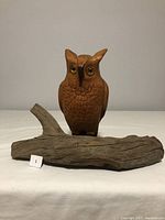 Straight front view of the wooden owl sculpture mounted on driftwood base.