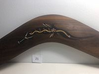 Close-up photo of the boomerang center decorated with snake design on dark wood.