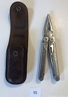 Photo of Leatherman Wave multi-tool and brown leather belt sheath, showing front side and open pliers tool.