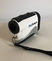 Front-left angle view of white and black Lofthouse ProScope 400X golf rangefinder with wrist strap visible