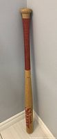 Full length view of the Louisville Slugger Big Daddy bat showing red grip and natural wood barrel with red lettering