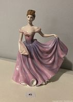 Front and side view of Royal Doulton figurine depicting a woman in a flowing pink and lavender gown holding a fan