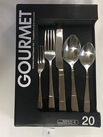 Open box showing 5 pieces of stainless steel flatware including a fork, knife, tablespoon, teaspoon, and salad fork.
