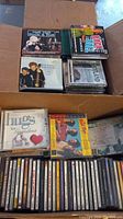 Two full boxes filled with various CDs from multiple genres including country, classical, contemporary and Christmas music.