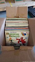 Box filled with vintage vinyl records with Walt Disney's Sleeping Beauty record visible on top