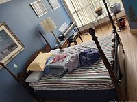 Full view of the four poster bed with bedding and mattress.