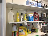 Wide view of 3 shelves showing household cleaners, Royale tissue boxes on top shelf, cleaning products including Sunlight, Lysol, Hoover detergent, and Great Value Oxi stain remover.