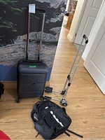 Photo showing the entire lot with suitcase, backpack, and trolley on a wooden floor against a rock patterned wall.
