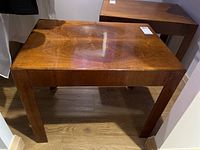 Front view of a wood side table showing the rectangular top with wood grain and light water spots.