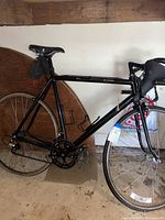 Side profile of black Cannondale bicycle showing frame, saddle, rear wheel, and drivetrain.