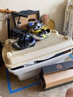 Bin with cycling shoes stacked on top, two hand pumps, and stacked trays visible
