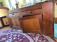 Full front view of wooden dry sink showing two drawers and two cabinet doors closed