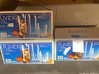 Boxes of Luminarc Riviera 18 piece glass sets showing packaging and brand details.