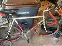 Full side view of cream and red road bike showing frame, wheels, drivetrain