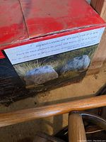 Box showing label '100 watt landscape speaker pair 8 ohm 2-way' with bilingual text and image of two rock-shaped gray speakers on grass.