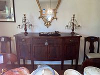 Full frontal view of serpentine front buffet showing top surface, three drawers with brass escutcheons, and lower cabinet doors