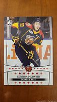 Front of the 2014 In The Game Connor McDavid rookie card showing him in Erie Otters uniform.
