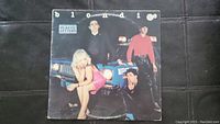 Plastic Letters album by Blondie front cover with band posing by a car.