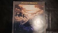 Front cover of Jackson Browne 'Running on Empty' vinyl album showing dramatic cloudy sky and drum set.