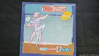 Cover of Dire Straits Extended Dance Play album with stylized figure against blue background and sun illustration.