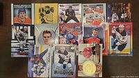 Photo showing the 13 assorted Connor McDavid hockey cards laid out on a surface, featuring various designs and editions.