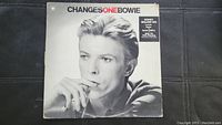 Front album cover of ChangesOneBowie vinyl record by David Bowie featuring black and white photo of Bowie.