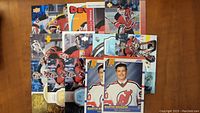Overhead view of 16 assorted Martin Brodeur hockey cards from different brands including Upper Deck and Score with New Jersey Devils uniforms.
