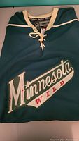 Front of the dark green Minnesota Wild jersey with the team name and logo.