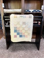 Front view of quilt draped over rack showing hand pieced country patch pattern.