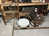 Overall view of wooden rack, dough bowl, crock, wooden rake, and military chest in basement setting