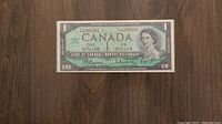 Obverse front side of the 1967 Canadian one dollar bill showing Queen Elizabeth II portrait and serial numbers.