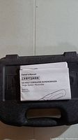 Closed black hard plastic case with owner's manual on top, labeled Craftsman 3.6 Volt Cordless Screwdriver manual.