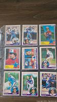 Lot of nine 1983 OPC baseball cards featuring Montreal Expos players in individual sleeves within a plastic baseball card holder.