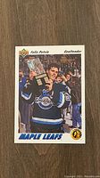 Photo showing the Felix Potvin rookie card with Potvin holding a trophy, dressed in Maple Leafs jersey.