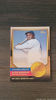 Front of Jackie Robinson 2023 Topps Golden Greats baseball card, showing batting pose and card design details
