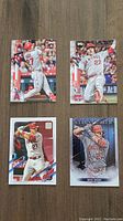 Front of 4 Mike Trout baseball cards showing images of player batting, pitching and action
