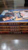 Stack of four Mr Bean DVDs with titles visible on the spines, showing 'Mr Bean - At Work' and some animated series.