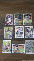 All 9 rookie baseball cards arranged on wooden surface showing front with players in action and clear team logos.
