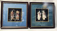 Framed pairs of slippers mounted on blue and green fabric mats inside dark wood frames, two pairs shown side by side.