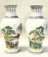 Front view of both vases showing hand painted landscape and black border design