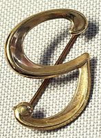 Front view showing stylized scroll shape and polished finish