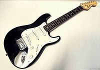 Full view of black Squier Mini Electric Guitar showing body, pickguard, and headstock.