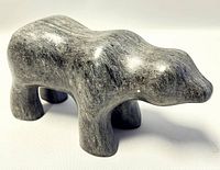 Side angle view of vintage soapstone bear carving showing polished stone texture and carving shape.