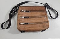 Front view of the brown Danier leather purse showing three horizontal zippered compartments with silver-tone zippers and black leather pull tabs on the exterior front.