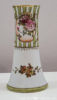 Front view showing floral medallion with pink flowers and gold detailing on vertical green and white stripes.
