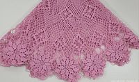 Close-up of the pink cotton stitched round table accent showing floral crochet lace and scalloped edges